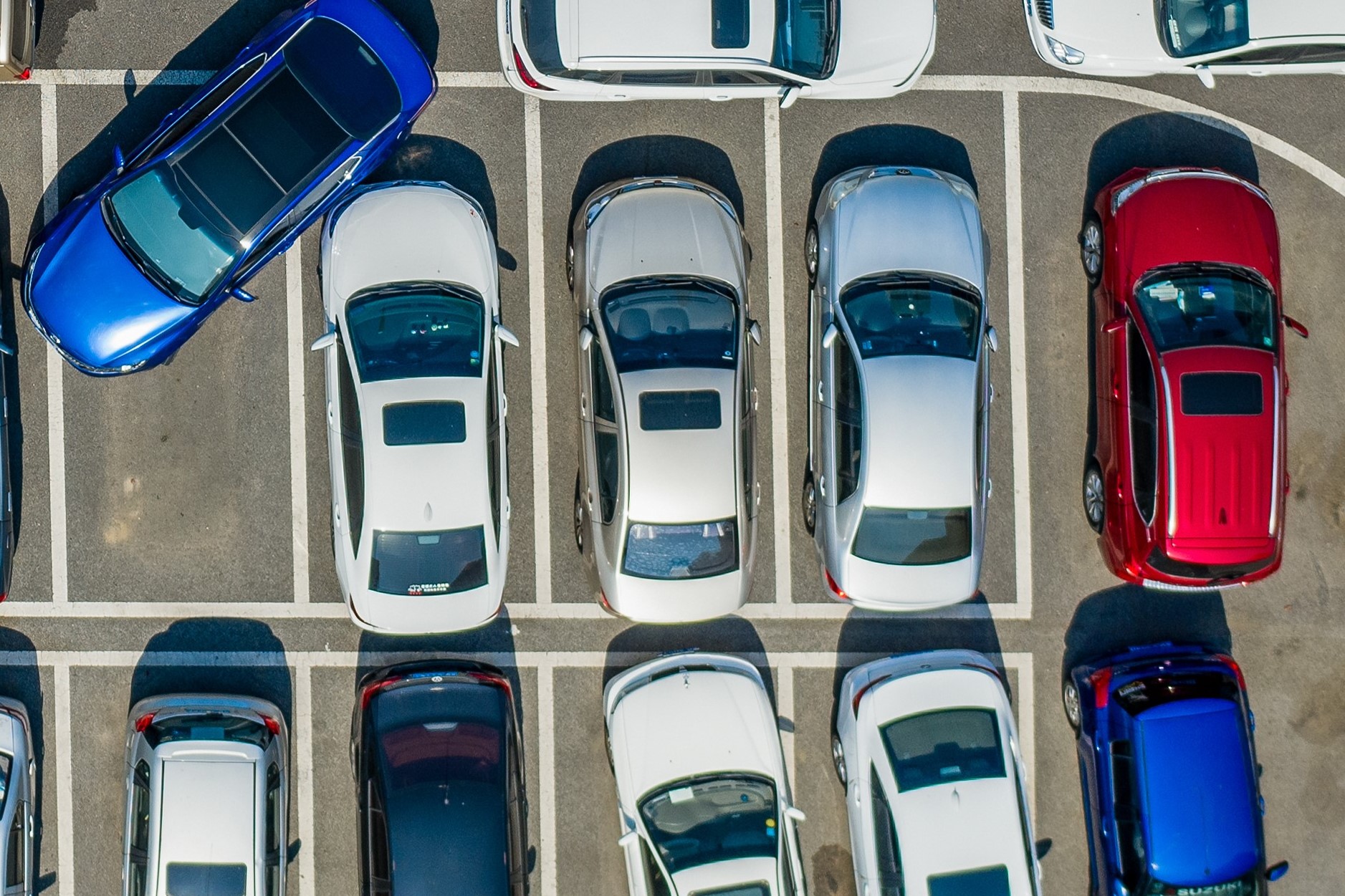 En bil prøver å parkere på en skikkelig trang parkeringsplass