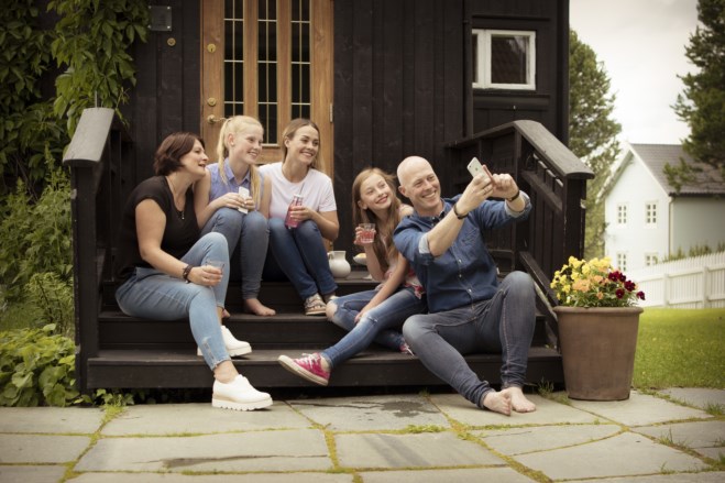 Familie sitter på trapp til hus